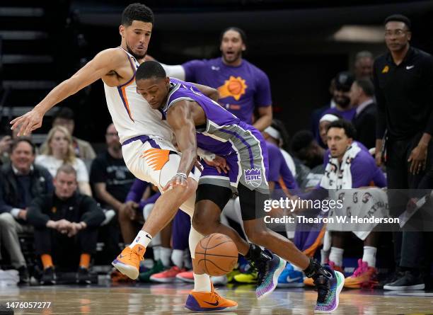 De'Aaron Fox of the Sacramento Kings dribbling the ball while being closely defended by Devin Booker of the Phoenix Suns during the second quarter at...