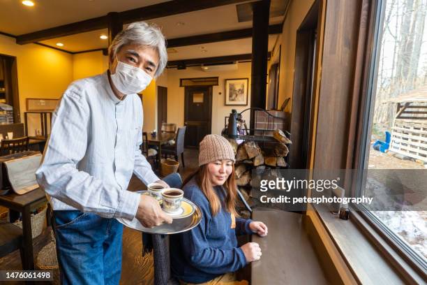 un hombre mayor sirviendo café a una clienta en una cafetería - prefectura de iwate fotografías e imágenes de stock