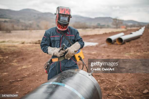 ein schweißer verwendet schweißgeräte, während er an einer rohrleitungsinspektion arbeitet - rohrleitung stock-fotos und bilder