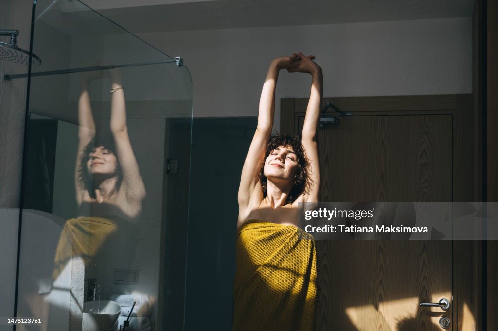 Beautiful young woman doing morning routine at home, sunny day.