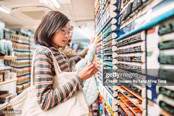 lovely cheerful girl shopping for art supplies in a store - craft supplies stock pictures, royalty-free photos & images