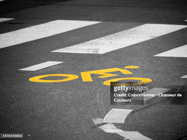 a road marking representing a cyclist in front of a pedestrian crossing in geneva, switzerland - schild schweiz stock-fotos und bilder