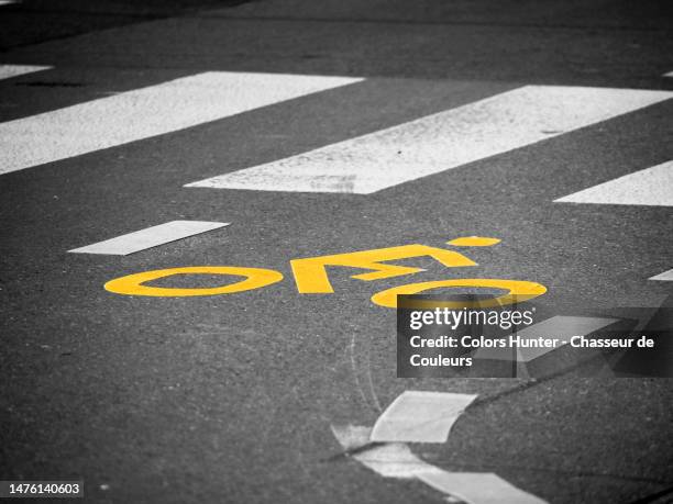 a road marking representing a cyclist in front of a pedestrian crossing in geneva, switzerland - paso peatonal raya indicadora fotografías e imágenes de stock