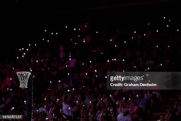 Fans hold torches as a power cut affects parts of the stadium during the round two Super Netball match between Adelaide Thunderbirds and NSW Swifts...