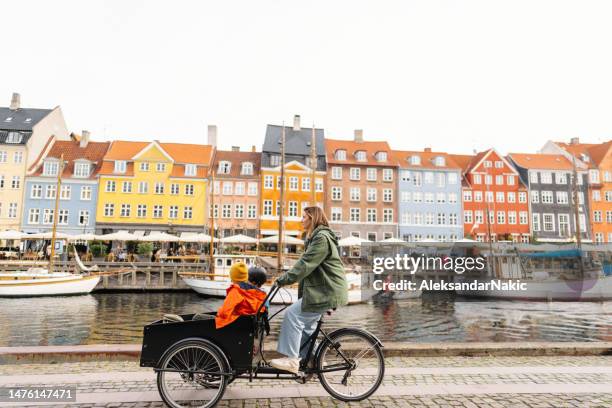 cargo bike ride with mom - two kids with cycle imagens e fotografias de stock