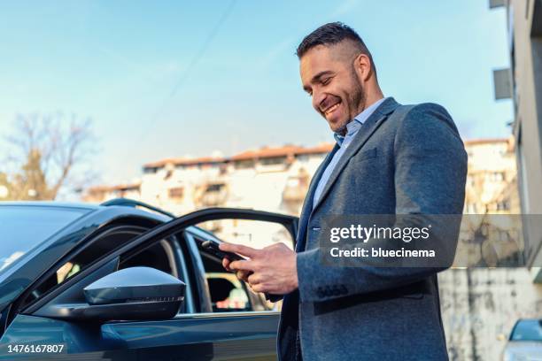 businessman standing near his car and using smartphone - management car smartphone stock pictures, royalty-free photos & images