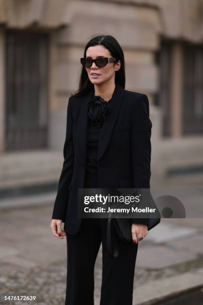 Leo Eberlin is seen wearing YSL brown sunglasses, Leo Mathild diamond jewellery, Zara black rose top, Zara black blazer and matching black suit...