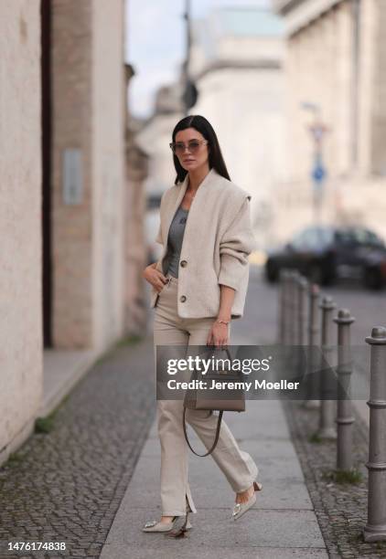 Leo Eberlin is seen wearing COS beige sunglasses, Leo Mathild diamond jewellery, Loewe grey knit logo top, Isabel Marant beige jacket, Zara beige...