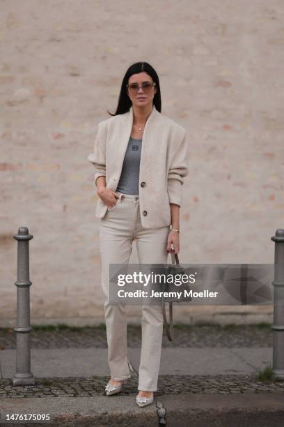 Leo Eberlin is seen wearing COS beige sunglasses, Leo Mathild diamond jewellery, Loewe grey knit logo top, Isabel Marant beige jacket, Zara beige...