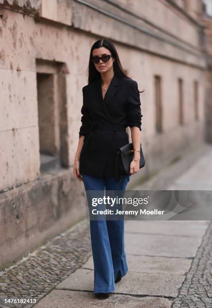 Leo Eberlin is seen wearing YSL brown sunglasses, Leo Mathild diamond jewellery, Toteme black blazer, Veronica Beard blue denim pants, Valentino...