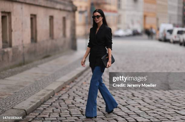 Leo Eberlin is seen wearing YSL brown sunglasses, Leo Mathild diamond jewellery, Toteme black blazer, Veronica Beard blue denim pants, Valentino...