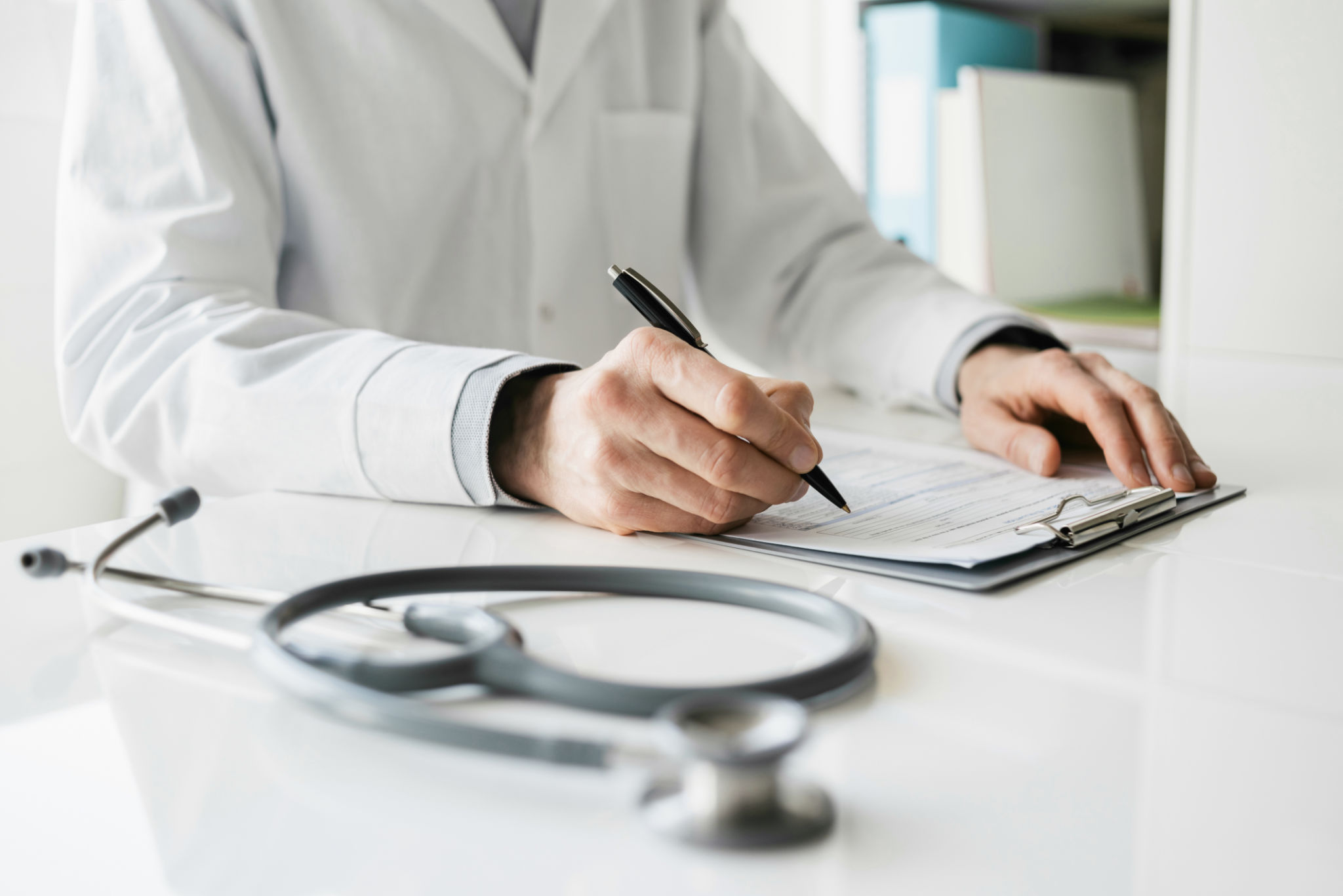 Doctor medical professional taking notes writing a prescription for patient Doctor medical professional taking notes writing a prescription for patient