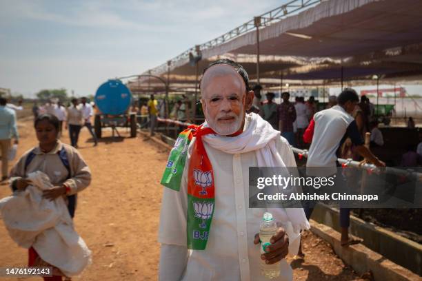 Man wears a mask in the likeness of India's Prime Minister Narendra Modi as he arrives to attend a political event organised by the Bharatiya Janata...