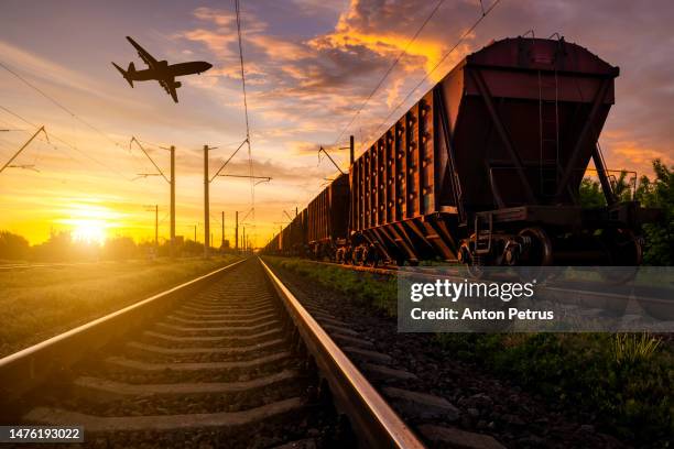 airplane over the railway and wagons. global shipping - aviación civil fotografías e imágenes de stock