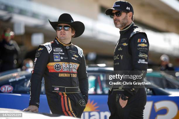 Noah Gragson, driver of the Black Rifle Coffee Company Chevrolet, and Jimmie Johnson, driver of the Club Wyndham Chevrolet, look on in the garage...