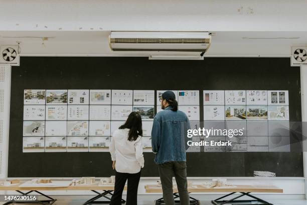 exposición de trabajo de estudiantes, profesor de arquitectura asiático está intercambiando ideas y compartiendo ideas sobre la tesis del examen final de diseño sostenible del proyecto de maestría - objetivos de desarrollo sostenible fotografías e imágenes de stock