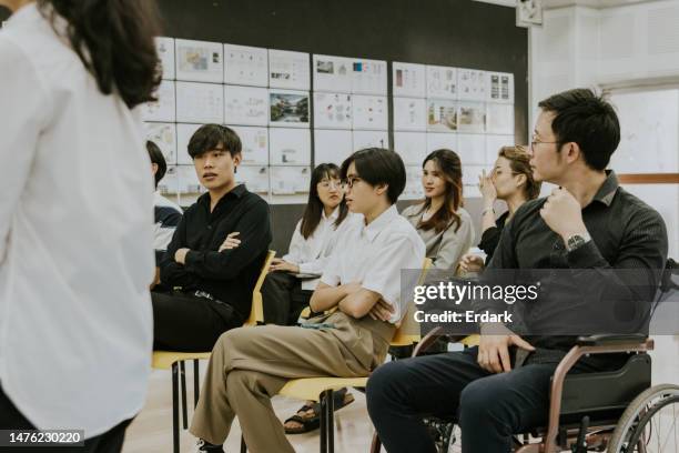 asian architect student and disability man who was studies master degree's in sustainable design come to sit in class. - 20 the exhibition stock pictures, royalty-free photos & images