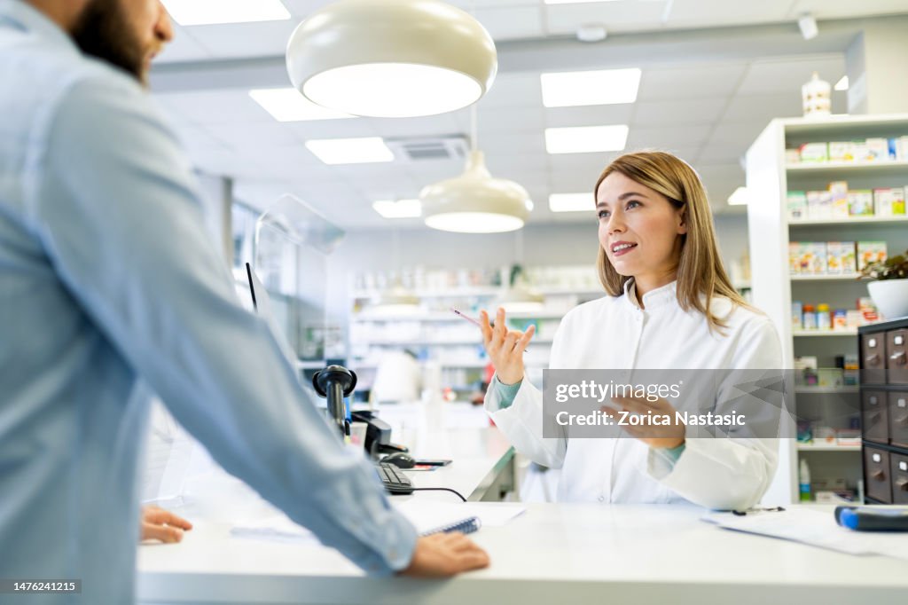 Farmacêutico que trabalha em drogaria conversando com cliente