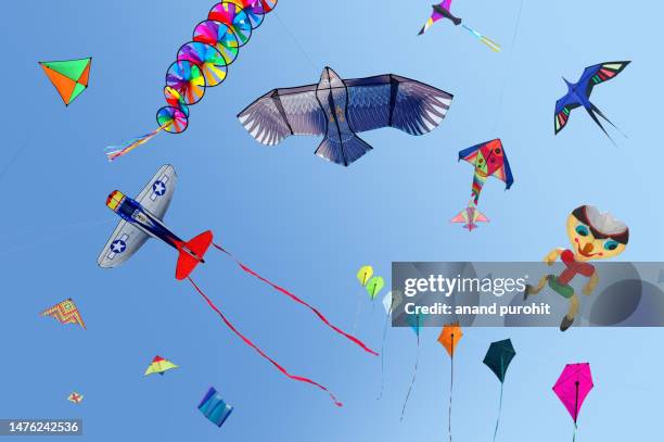 kites flying in clear blue sky - kite toy stock-fotos und bilder