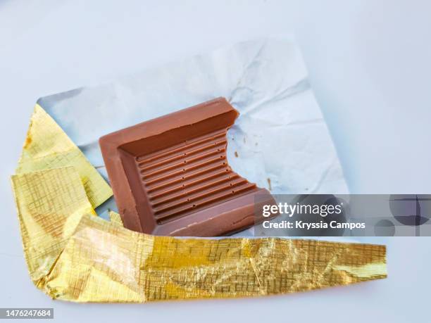 chocolate bar with bite in gold foil - break into small pieces imagens e fotografias de stock