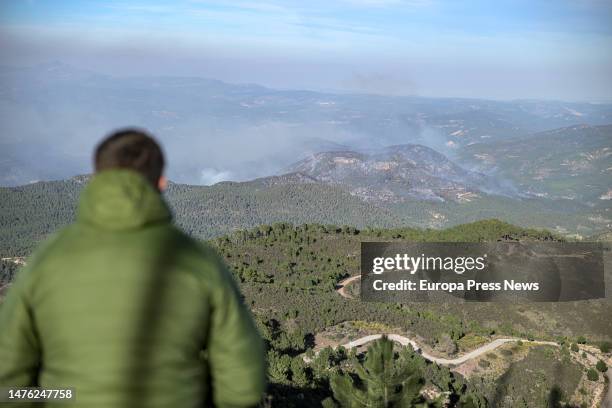 Man observes the smoke plumes of the forest fire between Castellon and Teruel seen from the Pico de Santa Barbara, on 25 March, 2023 in Pina de...