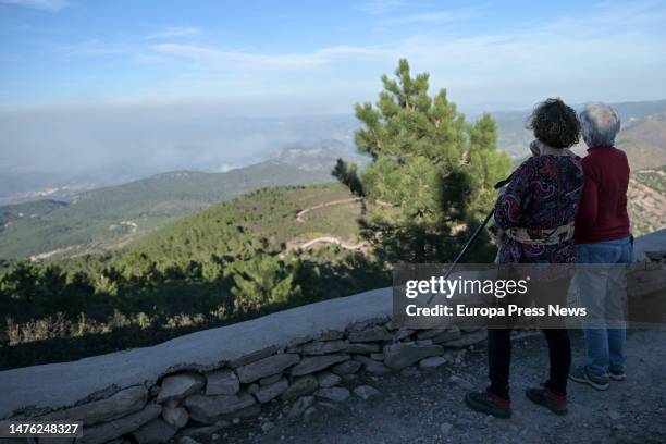 Two women look at the smoke plumes of the forest fire between Castellon and Teruel seen from the Pico de Santa Barbara, on 25 March, 2023 in Pina de...