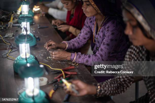 Indian villagers assemble solar lamps in a class held as part of the Barefoot Solar Project to bring solar powered lighting to rural areas on March...