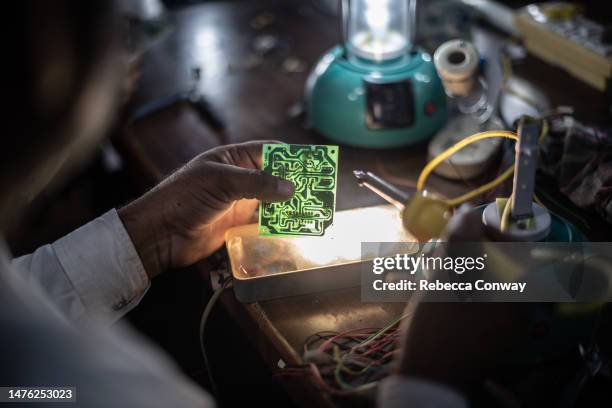 Indian villager Shayudan Gujar tests a circuit board for a solar lamp in a class held as part of the Barefoot Solar Project to bring solar powered...