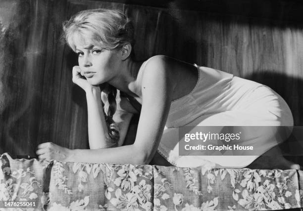 French actress Brigitte Bardot, kneeling with her chin resting on her right hand in a publicity still for the French crime drama 'Les bijoutiers du...