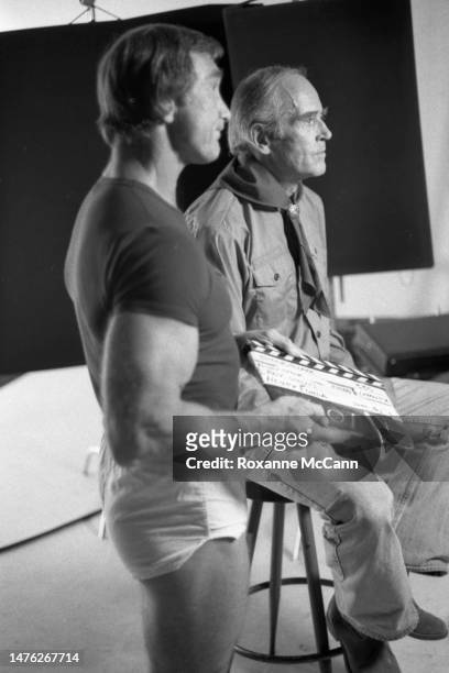 Electrician and former Mr. Universe John Isaacs holds a slate next to award-winning actor Henry Fonda, who is wearing a Boy Scout uniform, during...