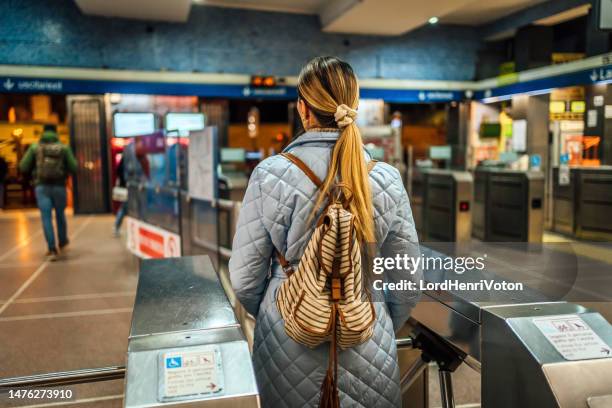 frau beim passieren eines fahrkartenschalters in einer u-bahn-station - fahrpreis stock-fotos und bilder