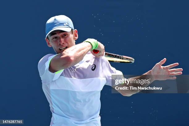 Alex de Minaur of Australia returns a serve to Quentin Halys of France during the Miami Open held at Hard Rock Stadium on March 25, 2023 in Miami...