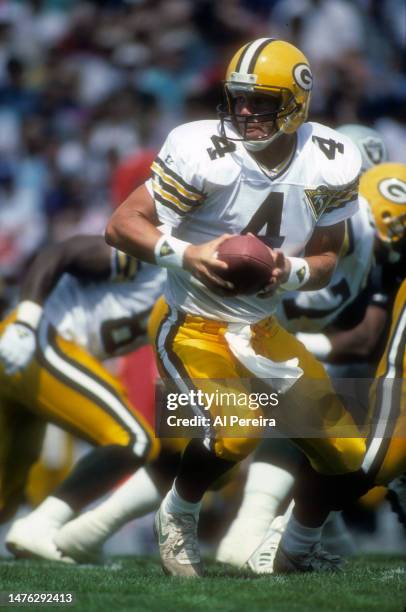 Quarterback Brett Favre of the Green Bay Packers turns to hand off the ball in the Pro Football Hall Of Fame Game between the Green Bay Packers vs...