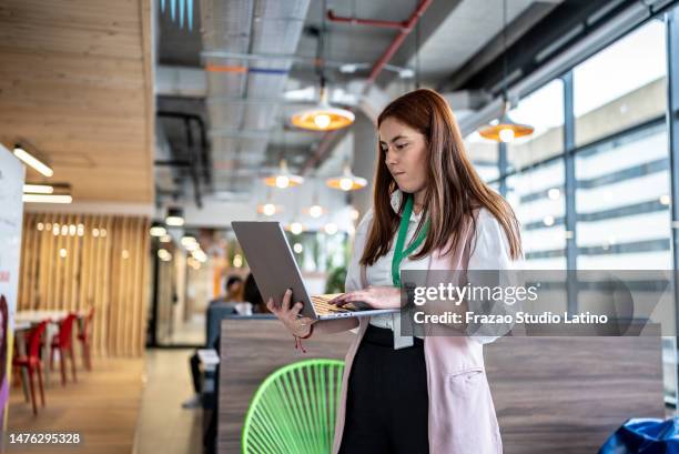 young businesswoman using laptop at office - employee badge stock pictures, royalty-free photos & images