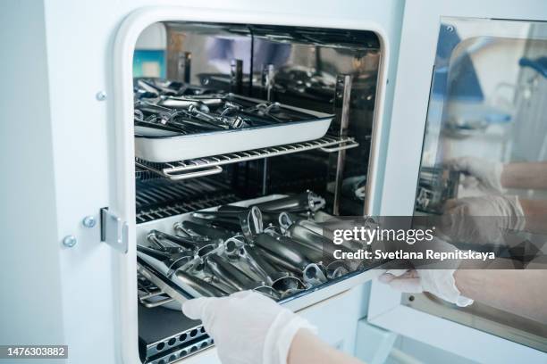 nurse doing sterilization of medical instruments in an autoclave - equipo quirúrgico fotografías e imágenes de stock