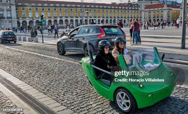 Tourists drive an electric convertible car by Praça do Comercio at the end of the afternoon on March 25, 2023 in Lisbon, Portugal. Revenue from...