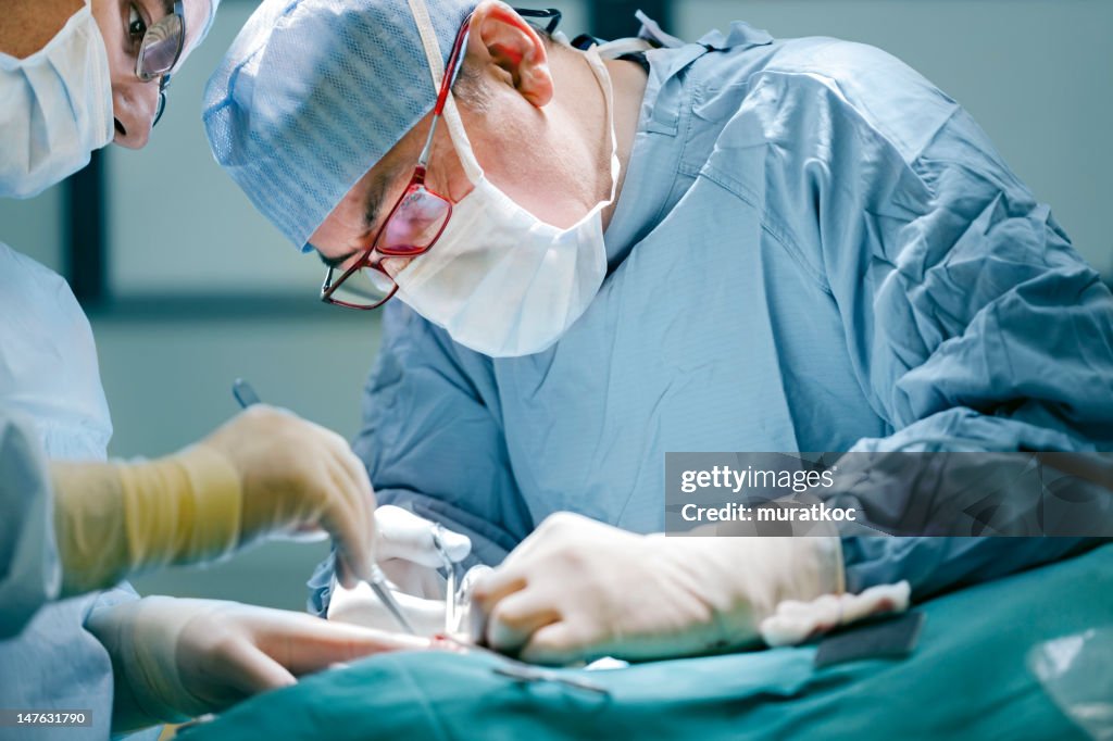 Surgeon performing surgery in full medical gear