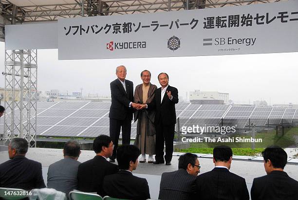 Kyocera Corporation founder Kazuo Inamori, Kyoto City Mayor Daisuke Kadokawa and Softbank Corporation Chairman Masayoshi Son shake hands during the...