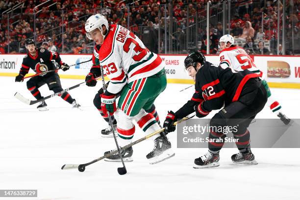 Alex DeBrincat of the Ottawa Senators controls the puck as Ryan Graves of the New Jersey Devils defends during the first period at Prudential Center...