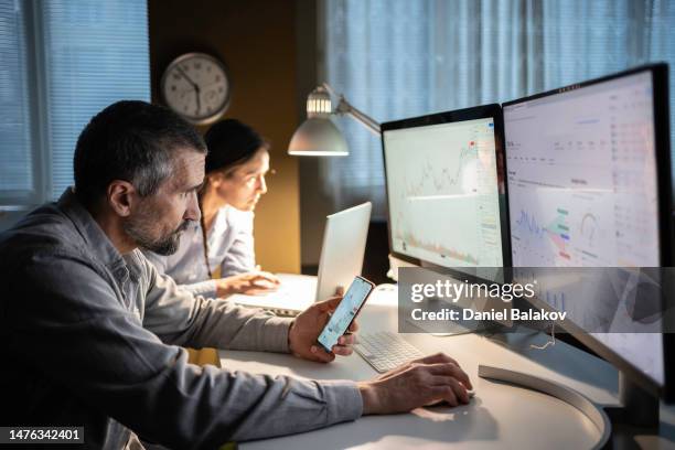 aktienhandel. die trader-familie studiert nachts die aktienmärkte in der tradingview-app. - risikomanagement stock-fotos und bilder