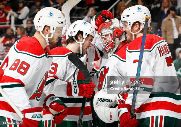 Kevin Bahl, Nico Hischier, and Dougie Hamilton celebrate with Mackenzie Blackwood of the New Jersey Devils after their win during the third period...