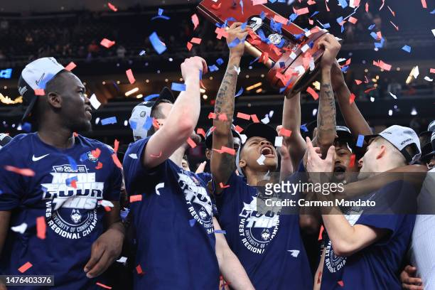 Jordan Hawkins of the Connecticut Huskies celebrates with teammates and the trophy after defeating the Gonzaga Bulldogs 82-54 in the Elite Eight...