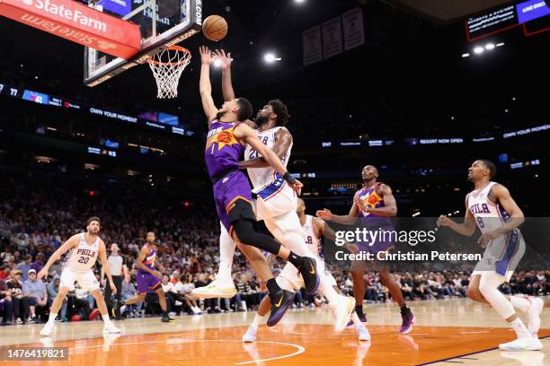 Devin Booker of the Phoenix Suns puts up a shot over Joel Embiid of the Philadelphia 76ers during the second half of the NBA game at Footprint Center...