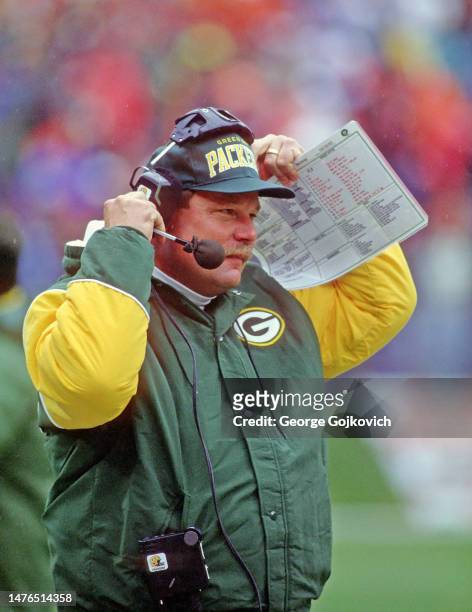 Head coach Mike Holmgren of the Green Bay Packers holds a play sheet as he looks on from the sideline during a game against the Cleveland Browns at...