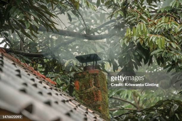 the tiled roof of the house with a chimney - traditional indonesian tile industry imagens e fotografias de stock