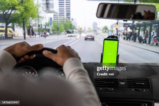 uomo che guida l'auto con lo smartphone attaccato al finestrino - cruscotto foto e immagini stock