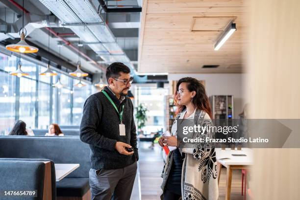 coworkers talking in the office - employee badge stock pictures, royalty-free photos & images