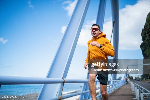 man enjoying his regular running session by the ocean. - portugal training session stock pictures, royalty-free photos & images