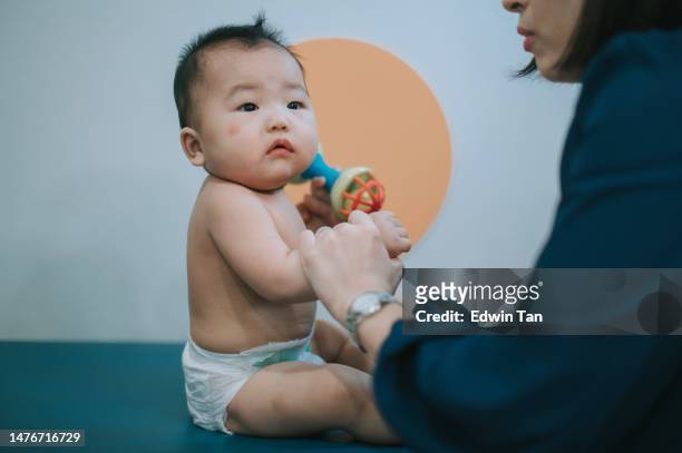 asian chinese female paediatrician examining baby boy in her clinic - mosquito bite stock pictures, royalty-free photos & images