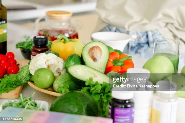 workplace of a nutritionist. served table with vegetables and fruits: large cabbage, broccoli, green salad and vitamin tablet - vitamin a stock pictures, royalty-free photos & images